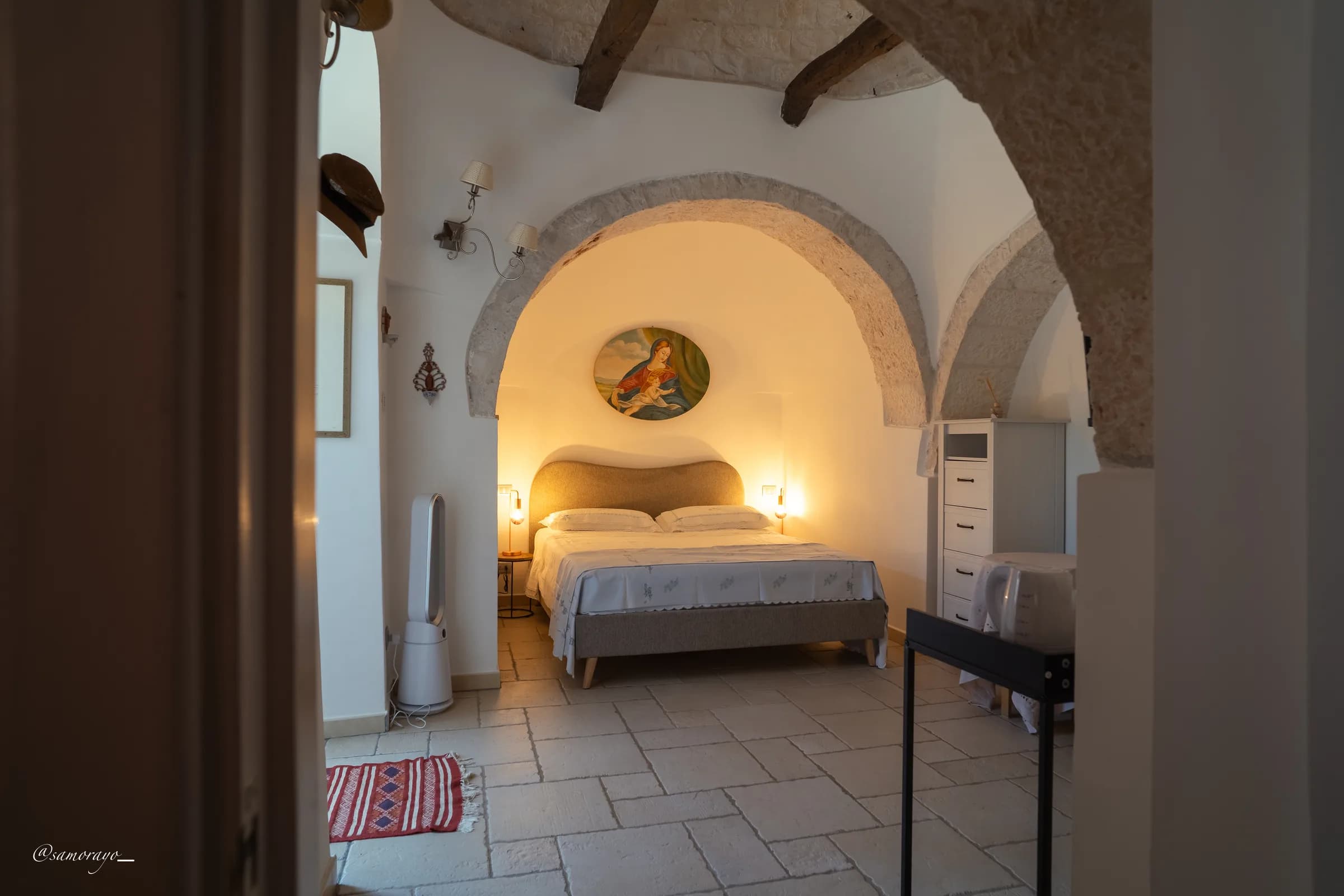 Il letto visto dall'ingresso, atmosfera serale con luci calde
